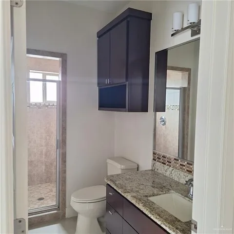 a bathroom with a granite countertop sink toilet and shower