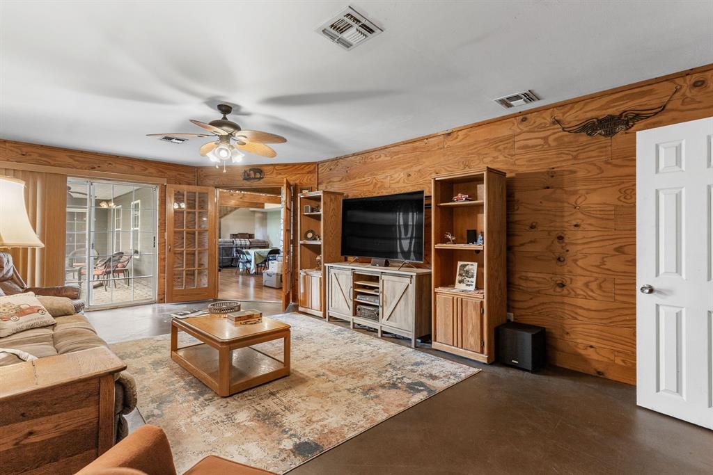 13315 Highway 281 Scotland, TX 76379 - Photo 14 of 40 Living/den area featuring wood-paneled walls and back patio access