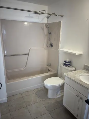 a bathroom with a granite countertop toilet a sink and a shower