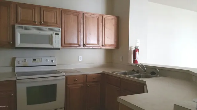 a kitchen with granite countertop a sink stove and cabinets