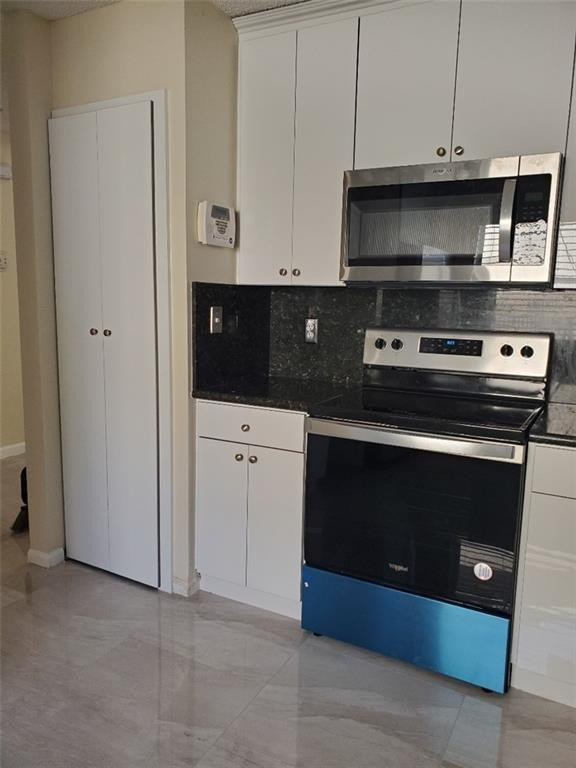 Undisclosed Address Miramar, FL 33029 - Photo 17 of 23 a kitchen with stainless steel appliances a stove and a microwave