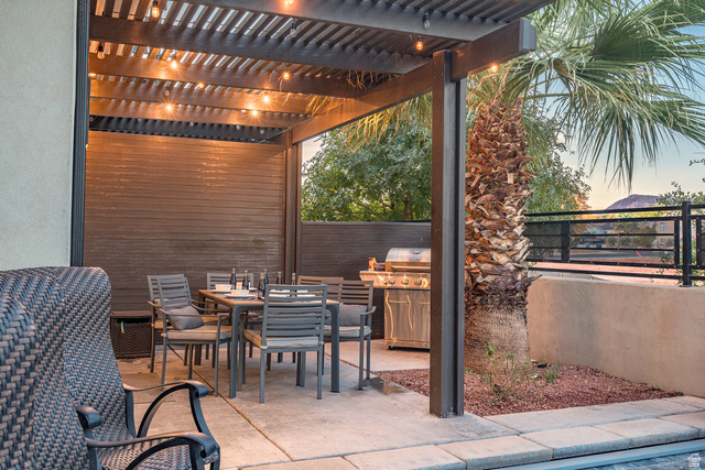 2600 Ocotillo Way, Unit 31 Santa Clara, UT 84765 - Photo 44 of 73 Outdoor patio featuring a dark wood-finish pergola with string lighting, a concrete patio surface, and a stucco retaining wall