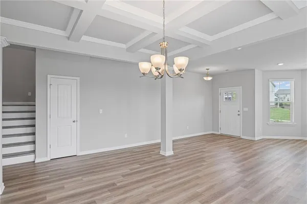 a view of an empty room with wooden floor and window