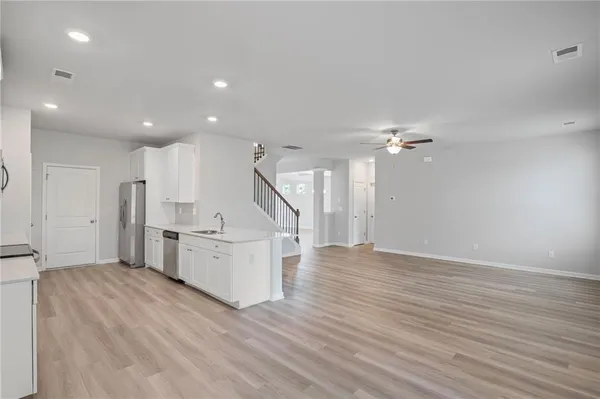 a view of kitchen with sink and refrigerator