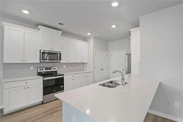 a kitchen with stainless steel appliances a sink stove and refrigerator
