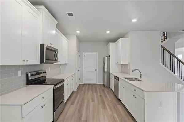 a kitchen with stainless steel appliances sink stove microwave and cabinets