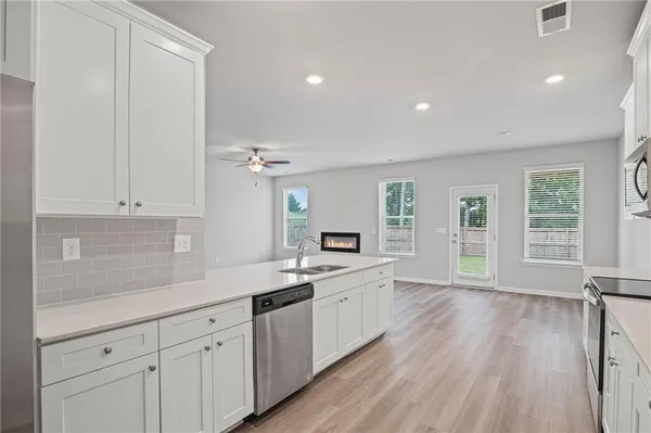a kitchen with granite countertop white cabinets and white appliances
