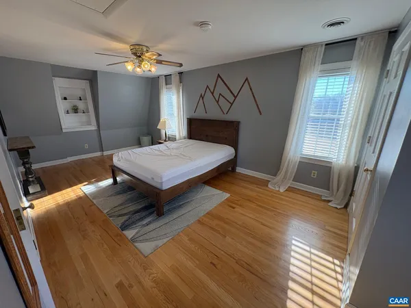 a bedroom with a bed window and wooden floor