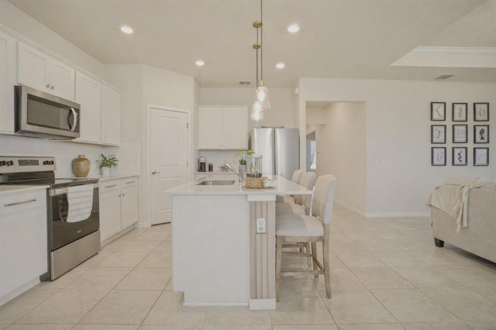 1821 Groveline Road St. Cloud, FL 34771 - Photo 17 of 36 a kitchen that has a lot of white cabinets and stainless steel appliances