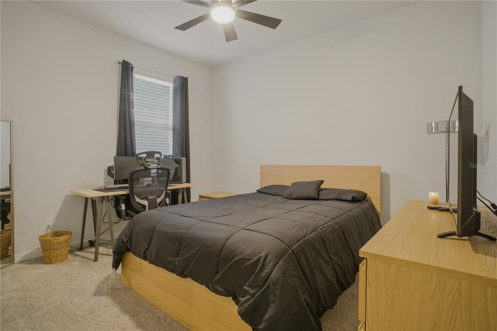 1821 Groveline Road St. Cloud, FL 34771 - Photo 18 of 36 a bedroom with a bed and a table in it