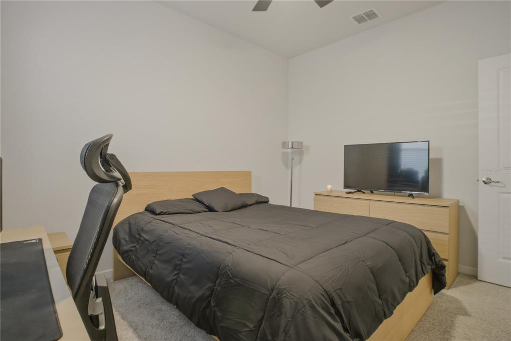 1821 Groveline Road St. Cloud, FL 34771 - Photo 19 of 36 a bedroom with a bed and a flat screen tv