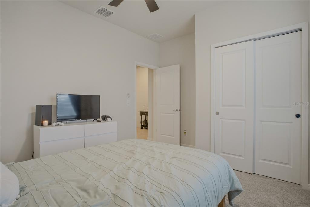 1821 Groveline Road St. Cloud, FL 34771 - Photo 20 of 36 a bedroom with a bed and a flat screen tv