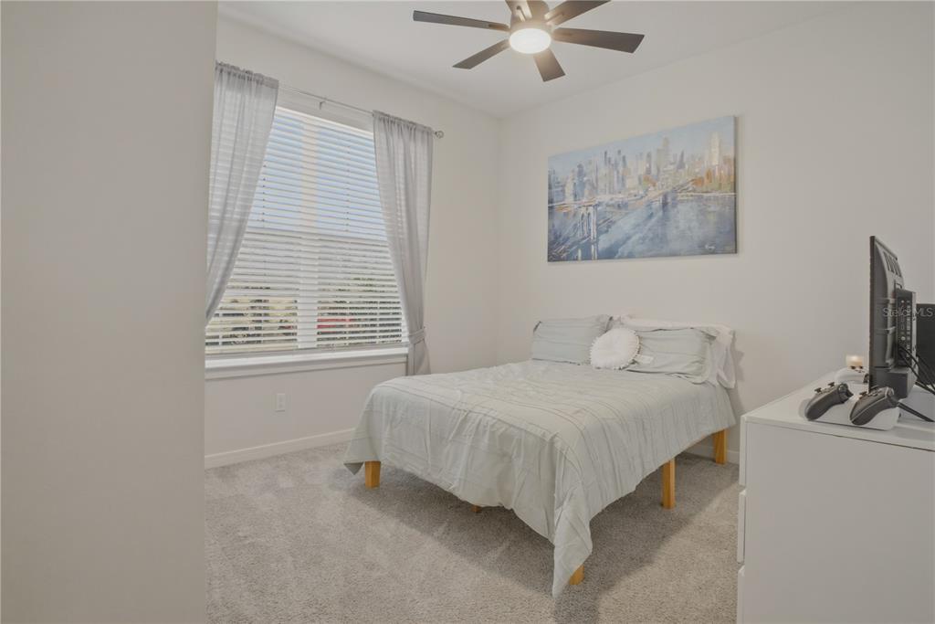 1821 Groveline Road St. Cloud, FL 34771 - Photo 21 of 36 a bedroom with a bed and a flat screen tv