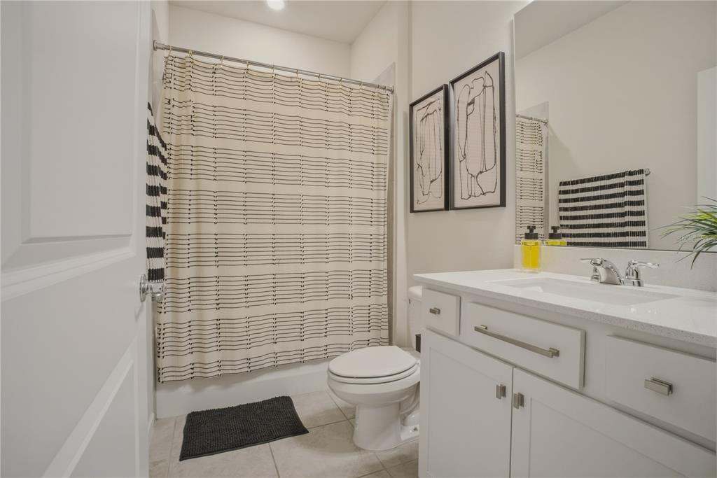 1821 Groveline Road St. Cloud, FL 34771 - Photo 23 of 36 a bathroom with a granite countertop toilet a sink a mirror and shower