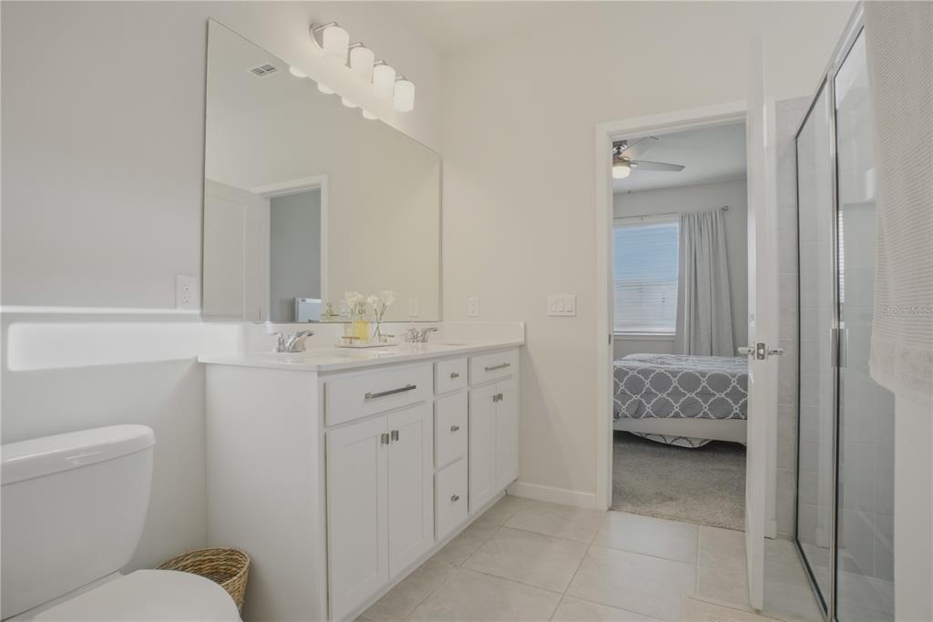 1821 Groveline Road St. Cloud, FL 34771 - Photo 25 of 36 a en suite bathroom with a granite countertop sink and a mirror