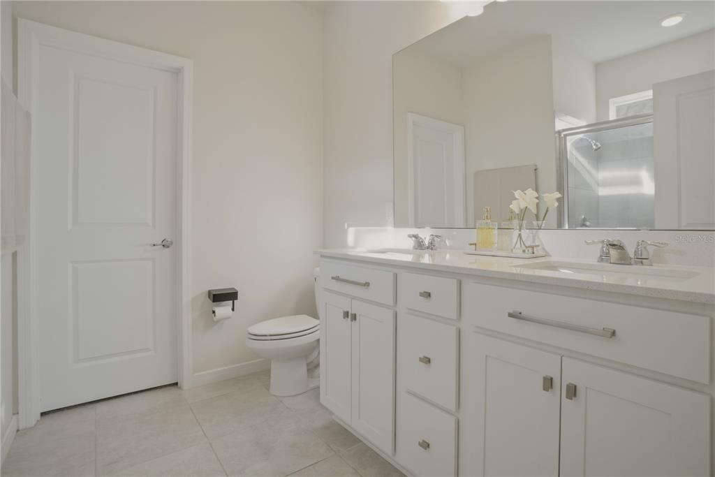 1821 Groveline Road St. Cloud, FL 34771 - Photo 27 of 36 a bathroom with a granite countertop toilet sink and mirror