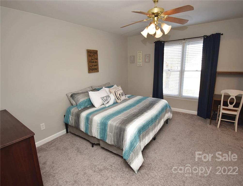 1909 Fletcher Broome Road, Unit 7 Monroe, NC 28112 - Photo 13 of 25 a bedroom with a bed and a chandelier