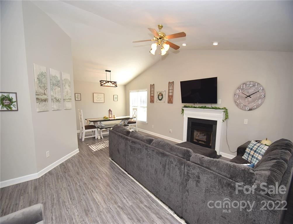 1909 Fletcher Broome Road, Unit 7 Monroe, NC 28112 - Photo 3 of 25 a living room with furniture a fireplace and a flat screen tv