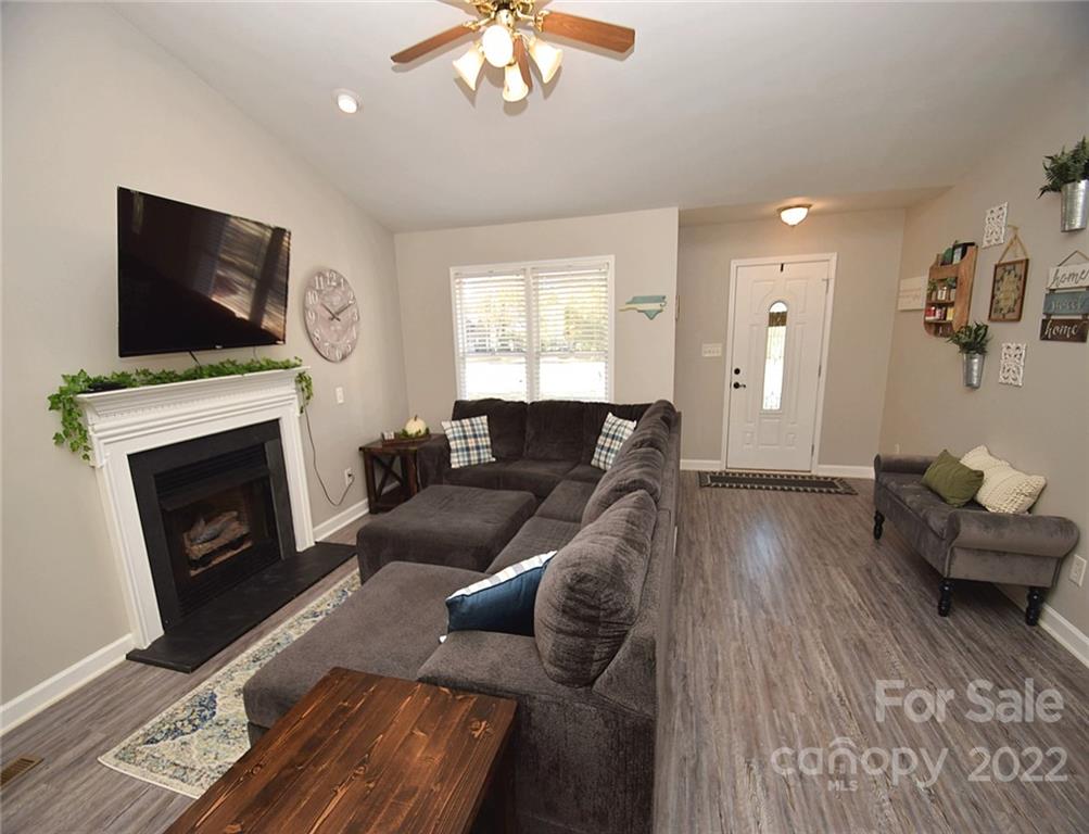 1909 Fletcher Broome Road, Unit 7 Monroe, NC 28112 - Photo 4 of 25 a living room with furniture a flat screen tv and a fireplace