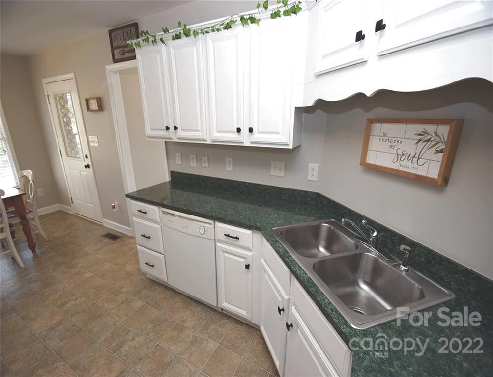 1909 Fletcher Broome Road, Unit 7 Monroe, NC 28112 - Photo 7 of 25 a kitchen with granite countertop a sink a stove and cabinets