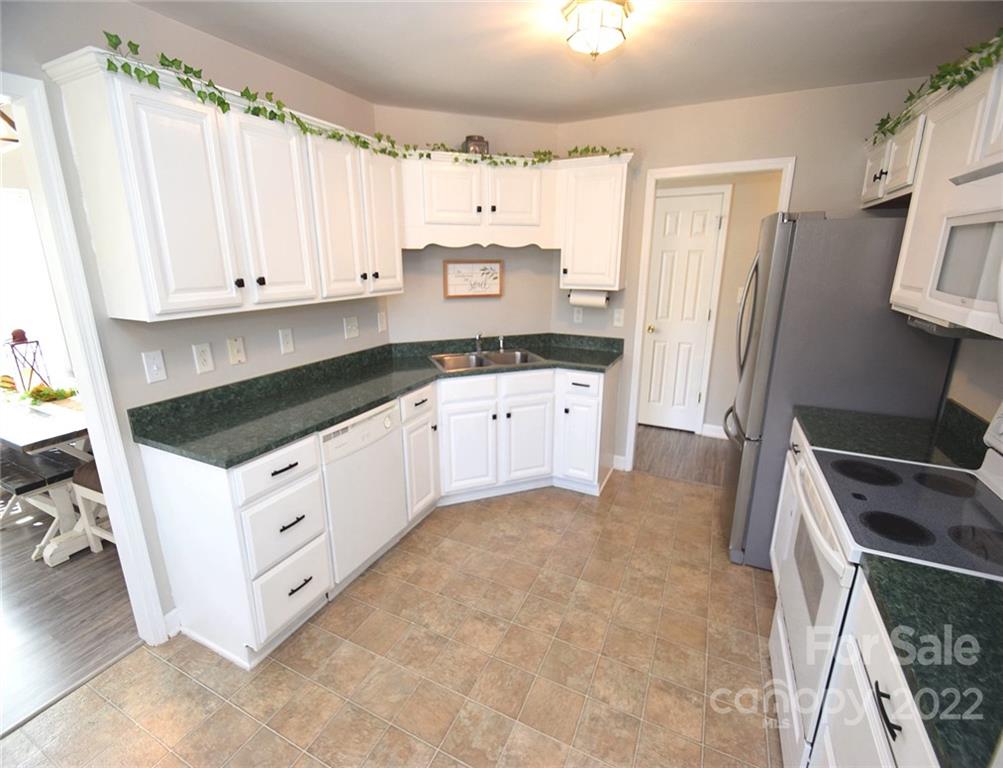 1909 Fletcher Broome Road, Unit 7 Monroe, NC 28112 - Photo 9 of 25 a kitchen with granite countertop white cabinets and white appliances