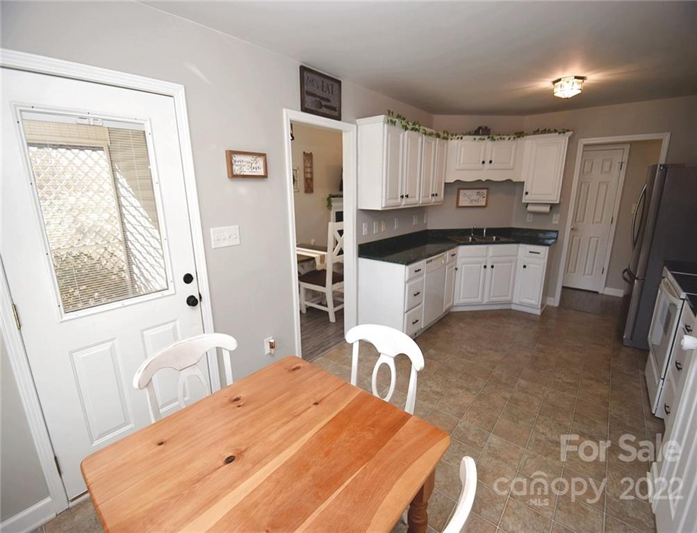 1909 Fletcher Broome Road, Unit 7 Monroe, NC 28112 - Photo 10 of 25 a kitchen with a refrigerator a stove a sink dishwasher and white cabinets with wooden floor