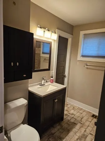 a bathroom with a toilet sink and mirror