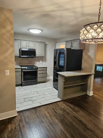 a kitchen with stainless steel appliances kitchen island granite countertop a stove and a microwave