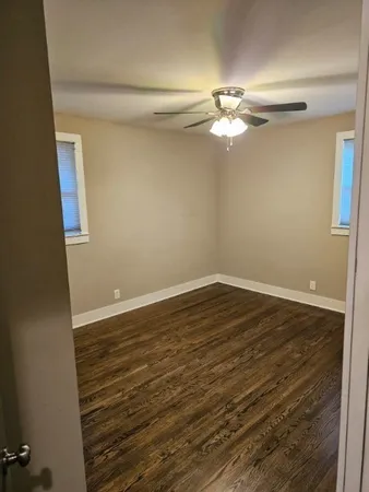 a view of a room with wooden floor closet and chandelier fan