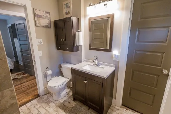 a bathroom with a granite countertop sink toilet and shower