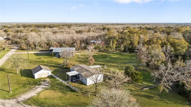 an aerial view of residential houses with outdoor space and trees
