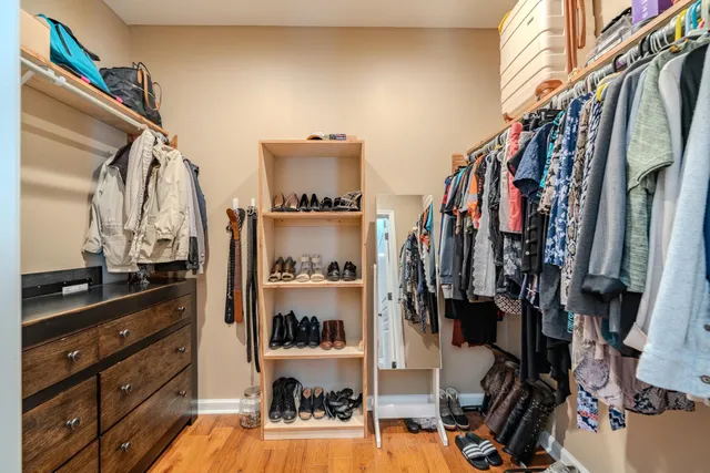 a view of walk in closet with clothes and shoes