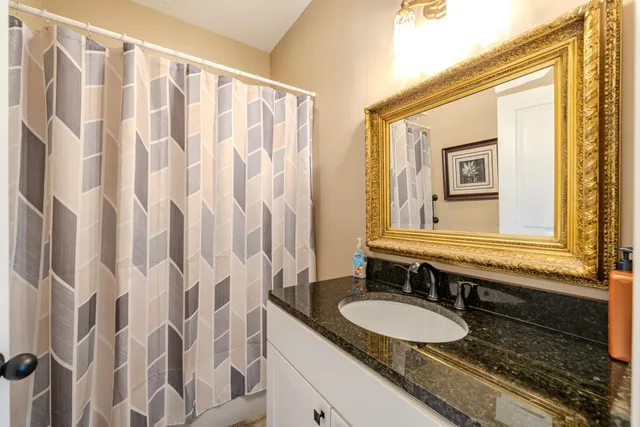 a bathroom with a granite countertop sink and a mirror