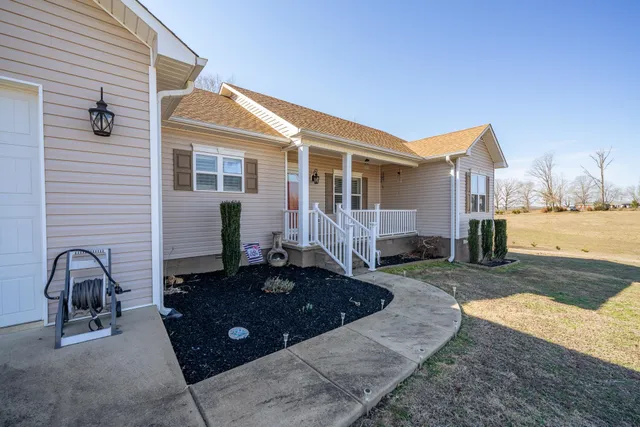 a view of a swimming pool with a bench and trees
