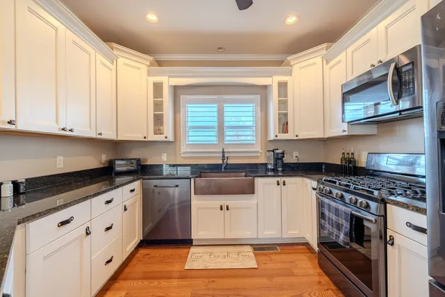 a kitchen with stainless steel appliances granite countertop a stove a sink and a microwave