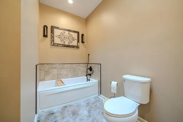 a white toilet sitting next to a bath tub