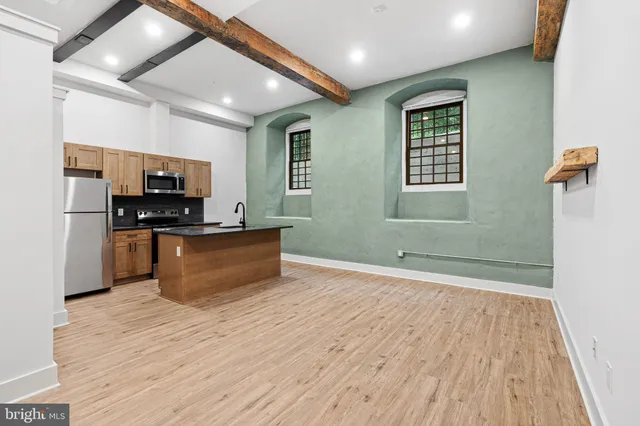 a kitchen with stainless steel appliances wooden floors and wooden cabinets