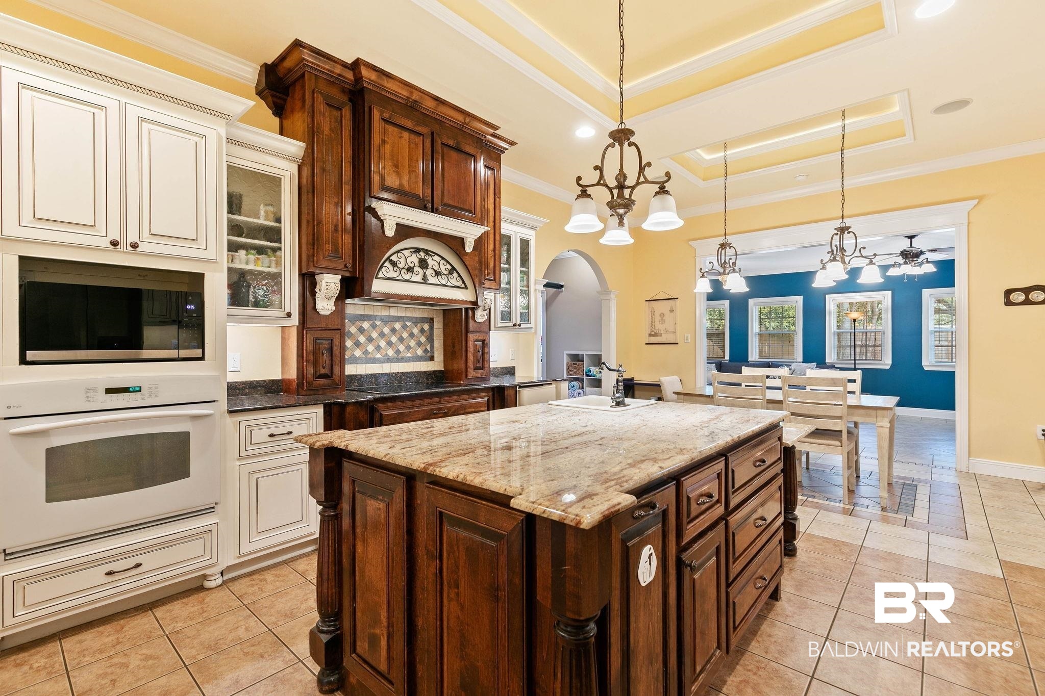 3668 Claridge Road North Mobile, AL 36608 - Photo 38 of 100 Two tone kitchen with two tone cabinets, oven, dark stone countertops, pendant lighting, and arched walkways