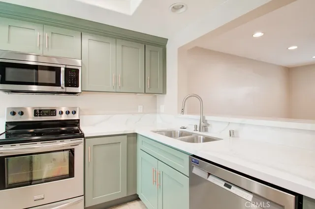 a kitchen with stainless steel appliances granite countertop a sink stove and microwave