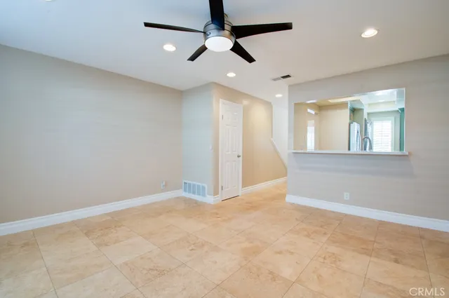 an empty room with fan and windows