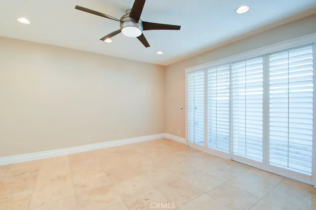 an empty room with a window and a fan