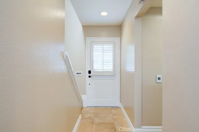 a view of a hallway with wooden floor and a bathroom