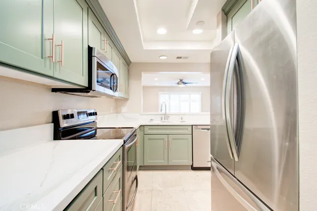 a kitchen with stainless steel appliances granite countertop a refrigerator sink and stove