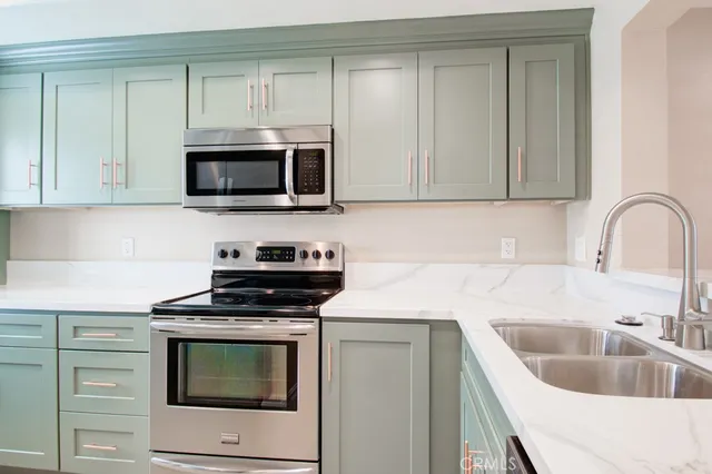 a kitchen with granite countertop a sink and a stove top oven