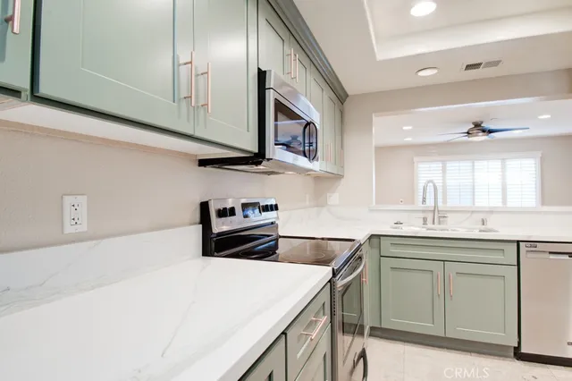 a kitchen with stainless steel appliances granite countertop a sink and a stove