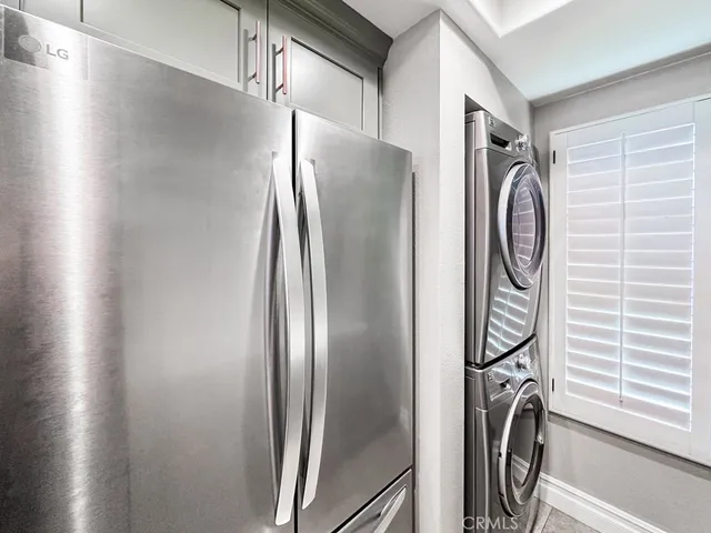 a view of a refrigerator in kitchen and a window