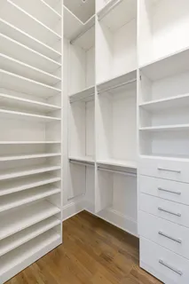 a view of walk in closet with empty racks