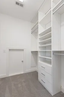 a view of walk in closet with empty racks