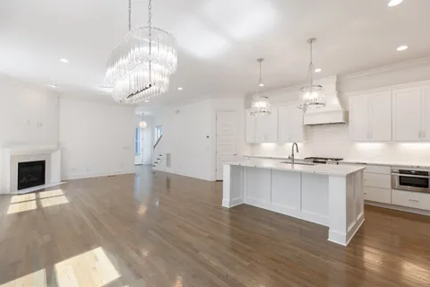 a large kitchen with cabinets wooden floor and stainless steel appliances