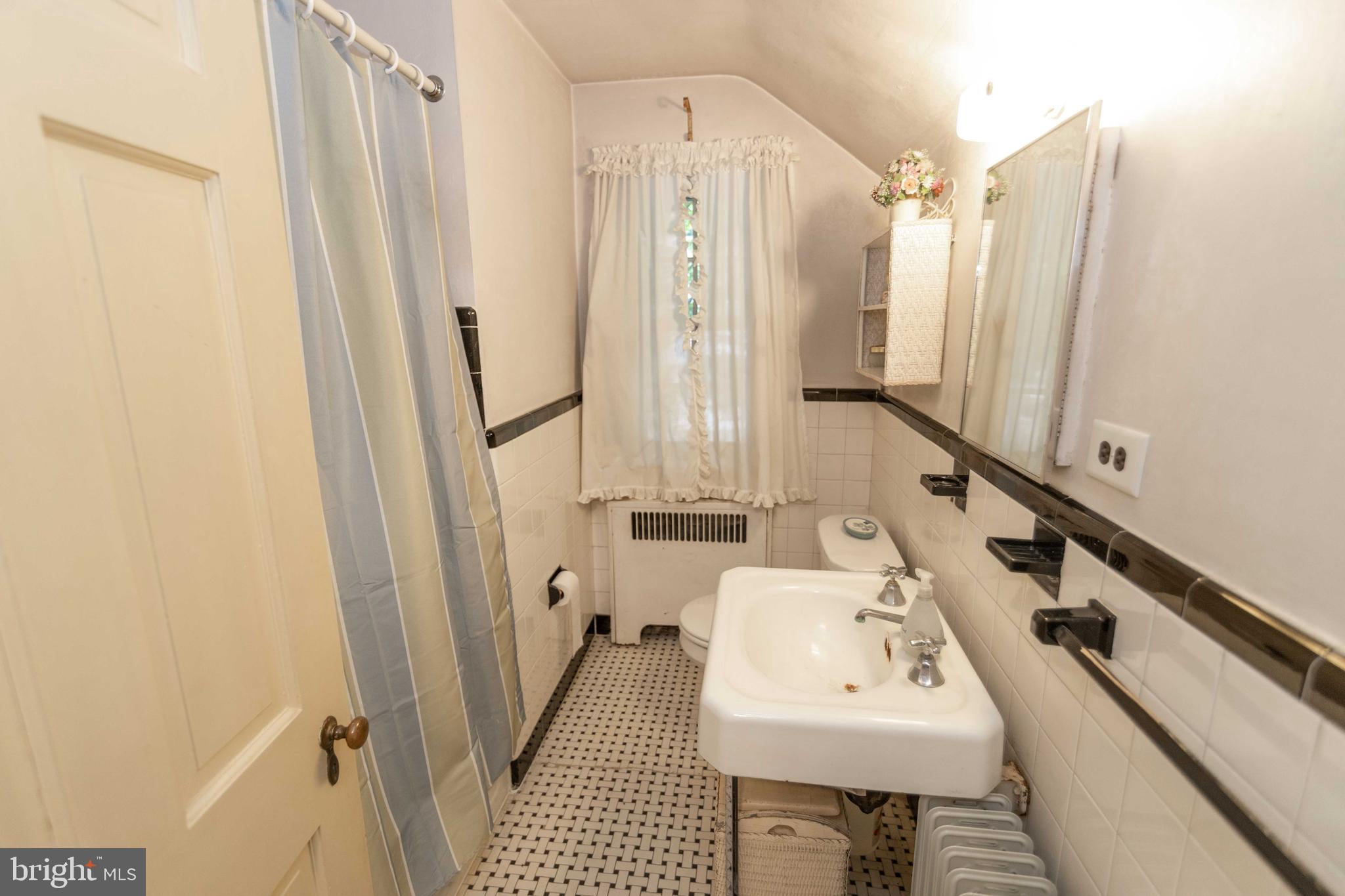 2 Green Valley Road Wallingford, PA 19086 - Photo 26 of 35 a bathroom with sink a mirror a bathtub and shower